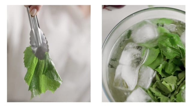 A grape leaf being blanched first in boiling water then in ice water.