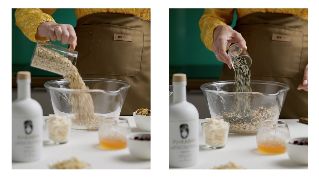 Granola being made. Oats and seeds added to a large mixing bowl.