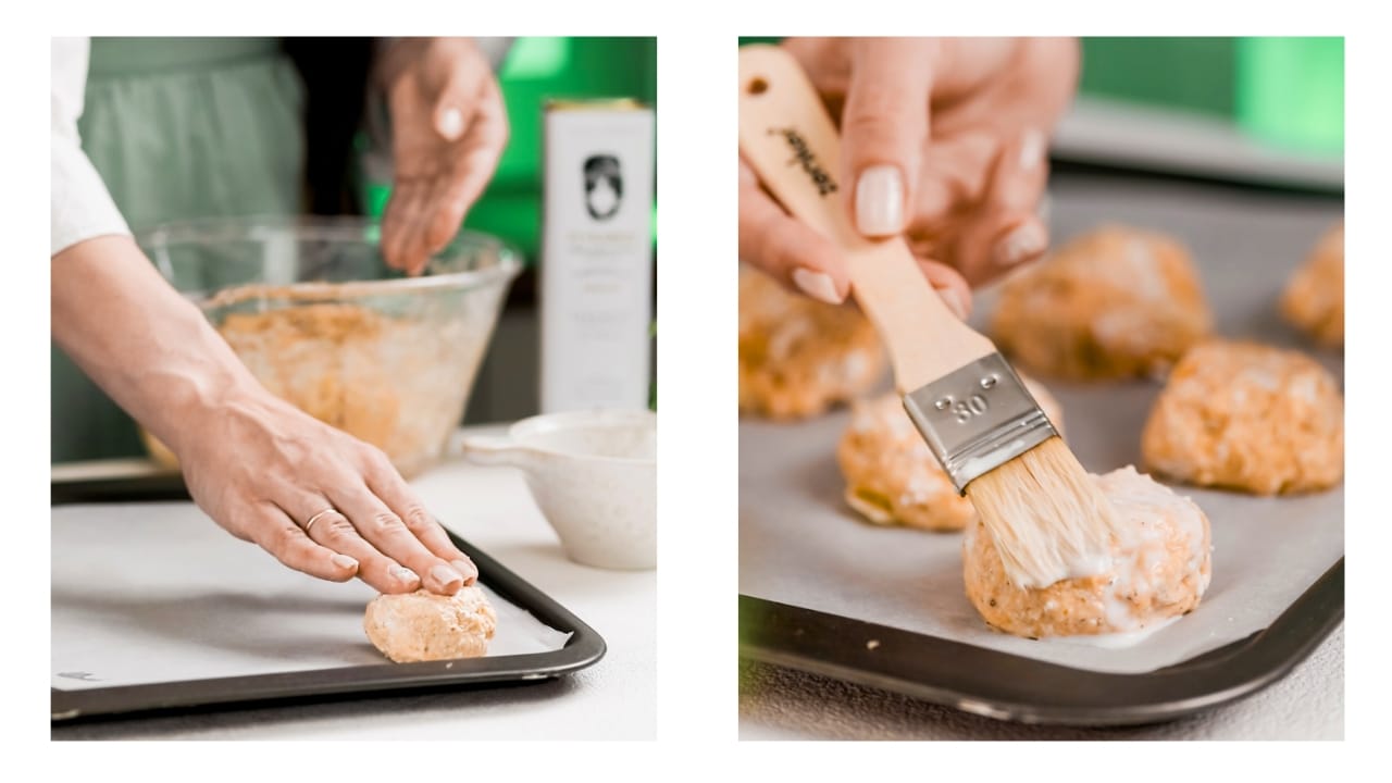 Placing the buns onto a cooking sheet and brushing each one with milk.