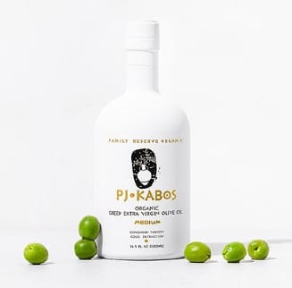 An elegant white bottle of PJ Kabos Medium High Phenolic Extra Virgin Olive Oil with olives scattered around it. Finishing oil, cooking oil and a phenolic shot.