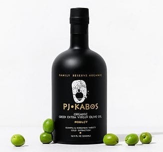 An elegant black bottle of PJ Kabos High Phenolic Robust Extra Virgin Olive oil with olives scattered around it. A finishing oil, cooking and baking oil and a phenolic shot.