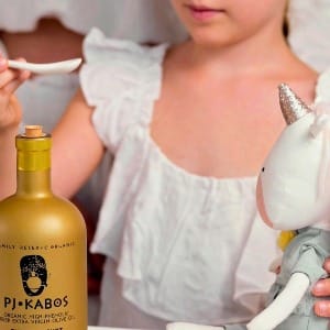 A little girl taking a phenolic "shot" of high quality extra virgin olive oil...and offering a spoonful to her doll, too!