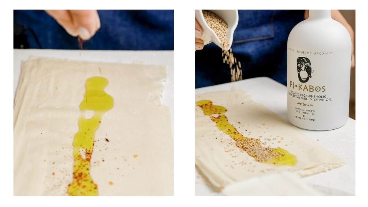 Chili flakes and sesame seeds being sprinkled over phyllo pastry.